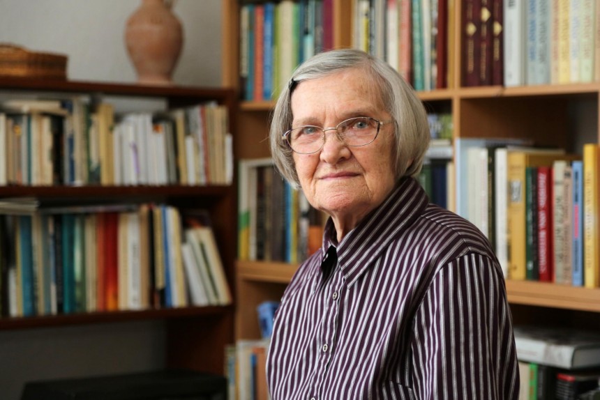 Lidijas Doroņina-Lasmanes portrets ar grāmatam fonā