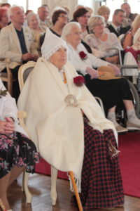 2017. gada Simtgadnieku Salidojums. Sieviete sēž tautastērpā. Foto: Ingrīda Punka