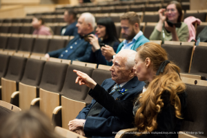 2025. gada Simtgadnieku Salidojums. Divi cilvēki sarunājas. Foto: Edgars Krinbergs