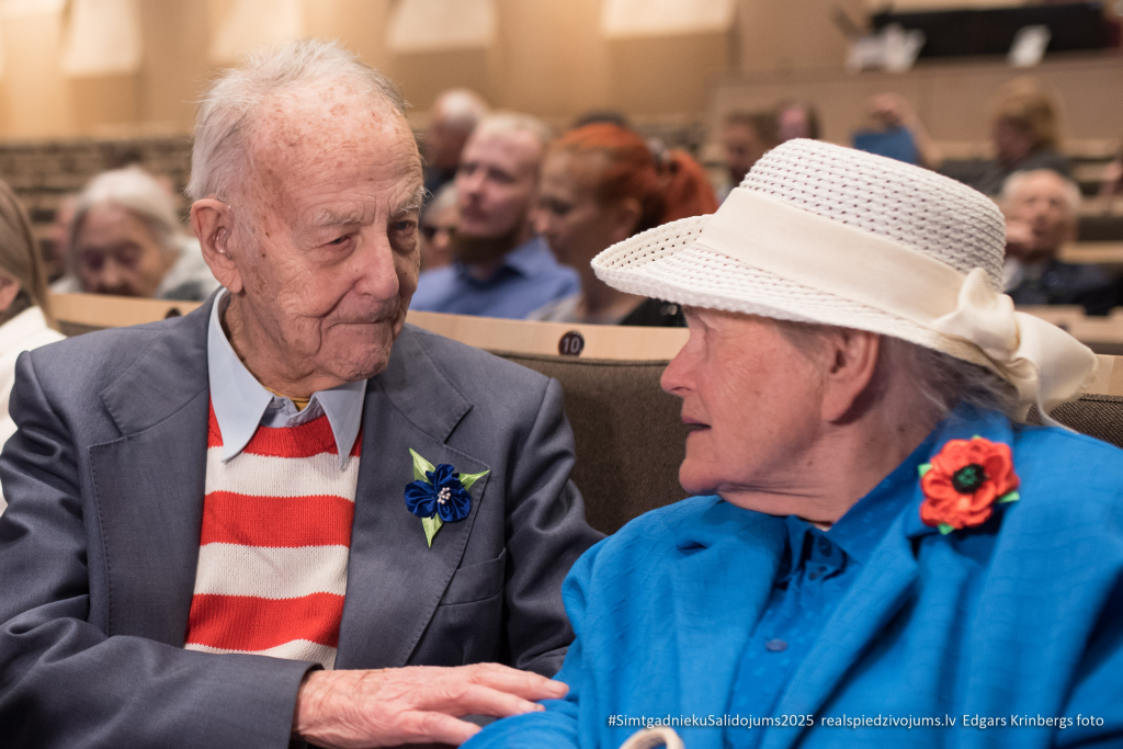 2025. gada Simtgadnieku Salidojums. Divi cilvēki sarunājas. Foto: Edgars Krinbergs