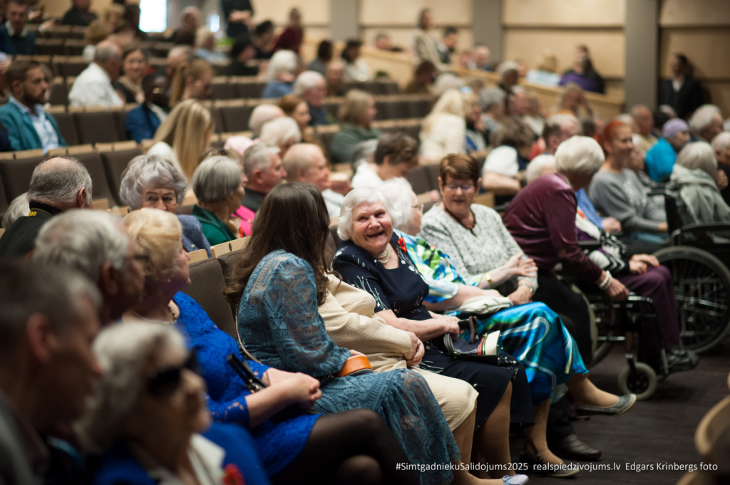 2025. gada Simtgadnieku Salidojums. Fokuss uz smaidīgu sievieti. Foto: Edgars Krinbergs