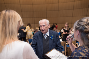 2025. gada Simtgadnieku Salidojums. Vīrietis sarunājas un smaida. Foto: Edgars Krinbergs