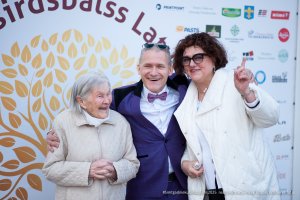 2025. gada Simtgadnieku Salidojums. Trīs cilvēki smaida. Foto: Edgars Krinbergs