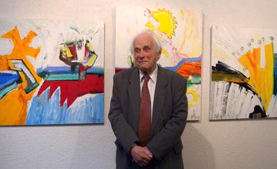 Valdis Bušs - portrets ar gleznam fonā